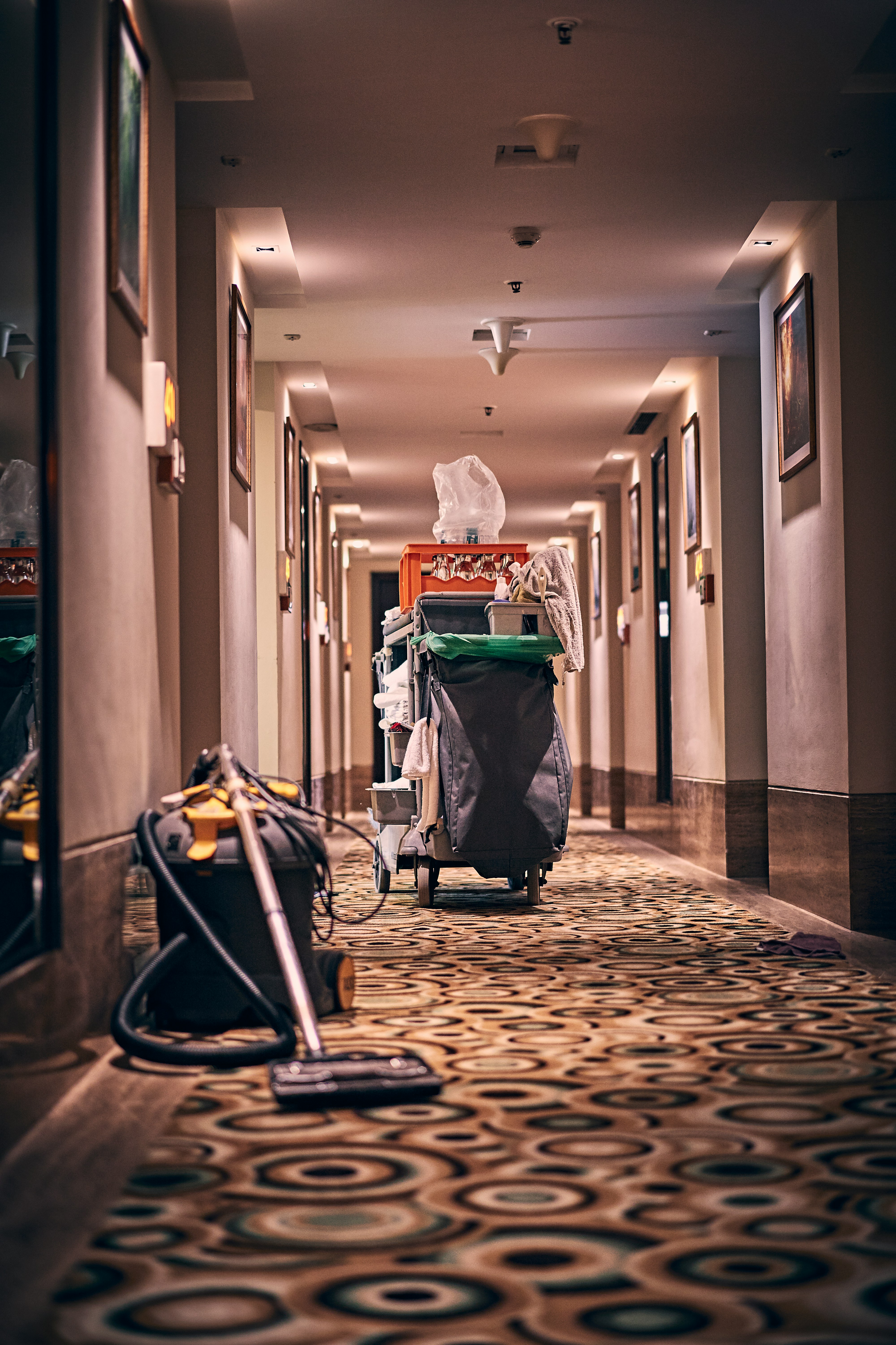 Janitorial cart and vacuum in a hotel corridor